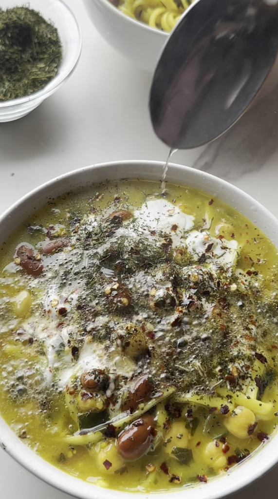 a bowl of aush/ash reshteh with hot oil drizzled over